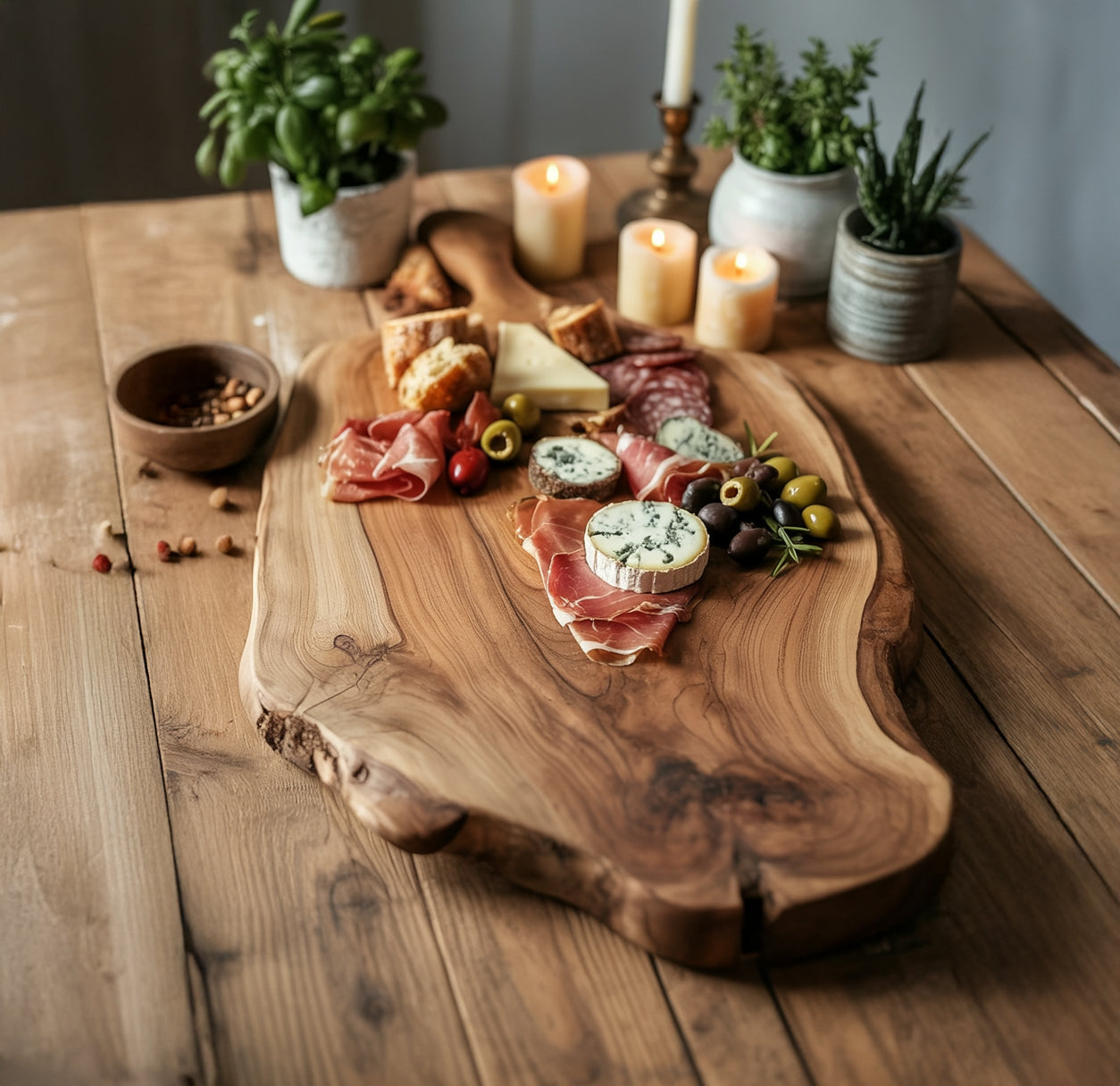 Charcuterie board with assorted meats, cheeses, olives, and bread on rustic wooden table with candles and potted herbs