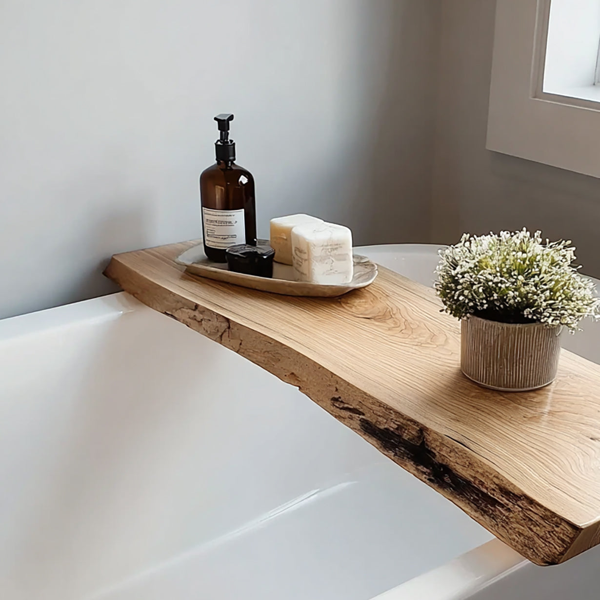 Wooden bathtub tray with soap, lotion bottle, and small plant in modern bathroom