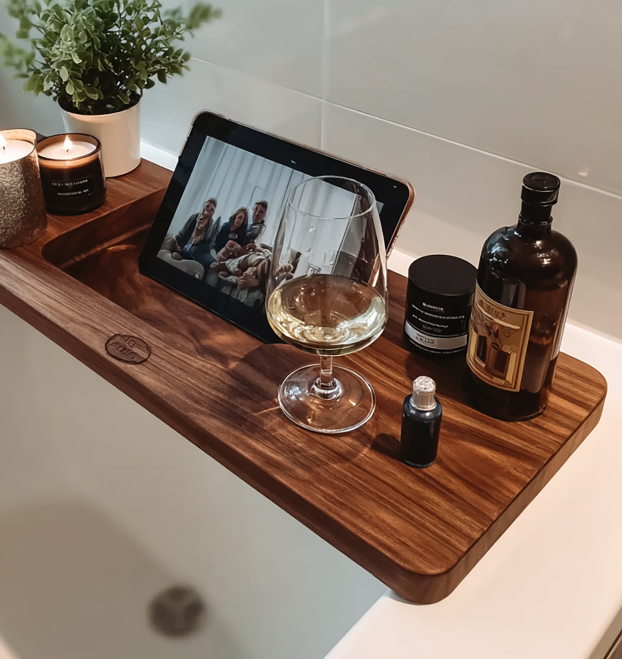 Wooden bathtub tray with candles, potted plant, wine glass, tablet, and bath products